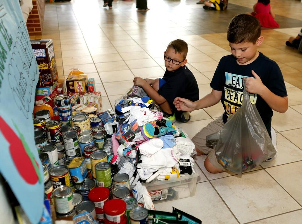 Zane Stahl, 6, and Drew Stahl, 9, place donated items in the pile for the Principals helping Principals project at Caprock Elementary School in Keller. In the wake of Hurricane Harvey, Caprock has adopted Houson's Kenneth J. Tice Elementery School.