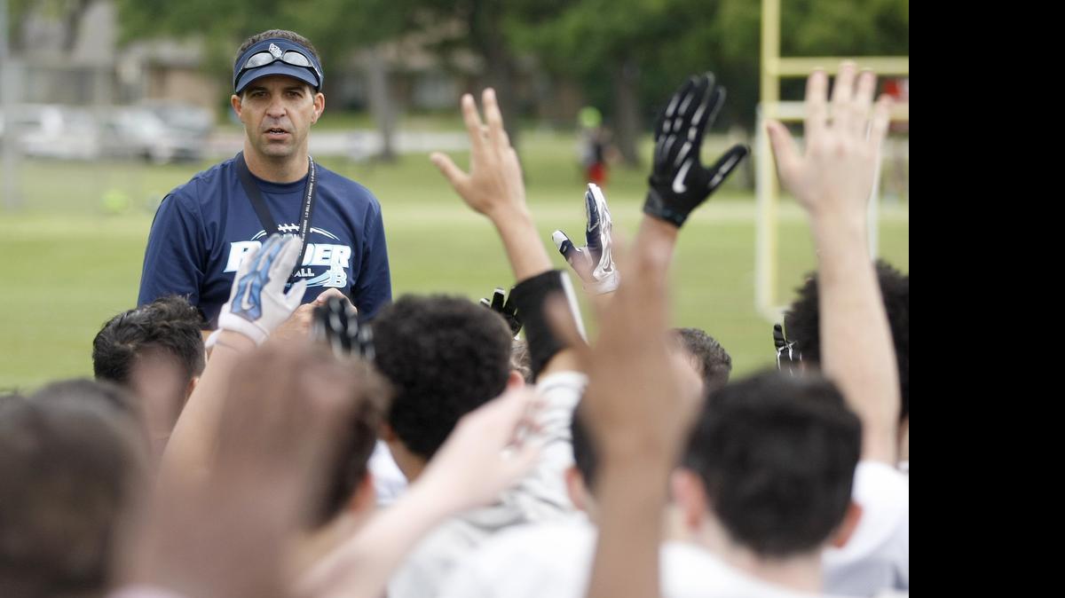 
L. D. Bell High School head football coach Mike Glaze talks with his players after their first spring football practice.
