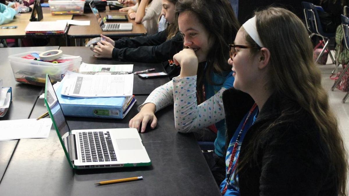 Colleyville Middle School students Danielle Sandlin (right) and Isabella Marks share a laptop.