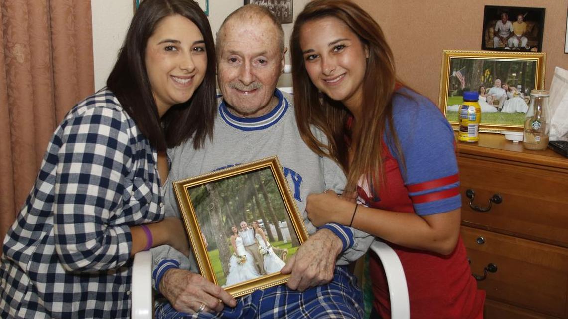Scott Duncan shows off a bridal photo of his daughters, Sarah and Becca at Keller Oaks Healthcare Center Aug. 28, 2016. Becca and Sarah Duncan pre-planned their weddings to include a bridal portrait with their father.