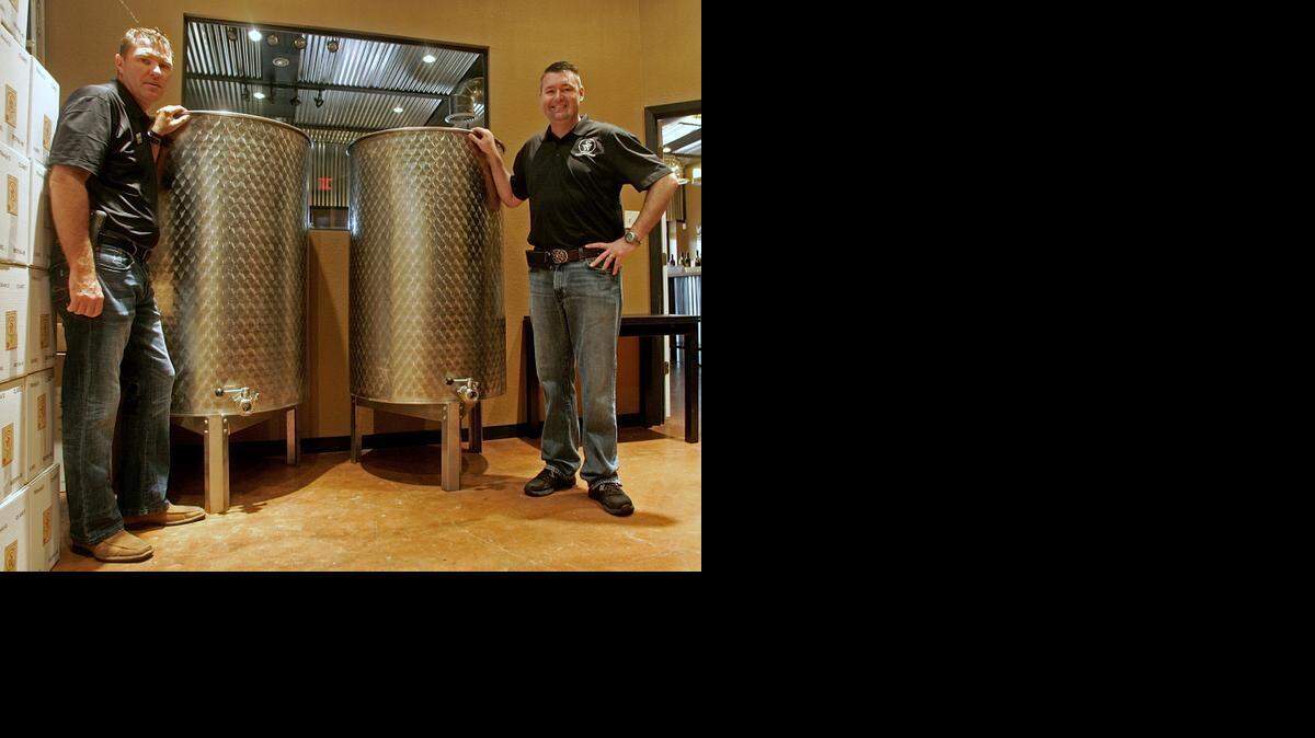 
Ralph Mattison Jr., left, and Alan Kunst Jr. at Sloan & Williams Winery with two of their wine vats.


