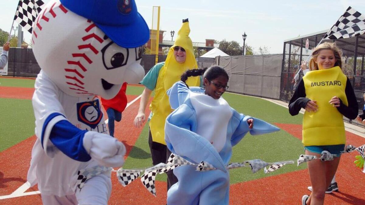 The Southlake Miracle League mascot, left with other costume characters race along the baseline between games.