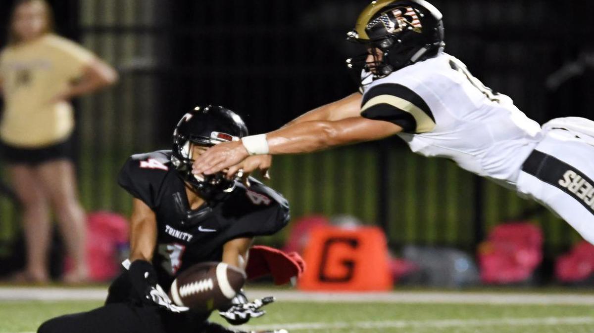 Trinity’s Corde Burns, left, brings in a catch for a first down against Broken Arrow, Okla. Burns had more than 100 receiving yards, a high total for a position the Trojans often utilize more for blocking.