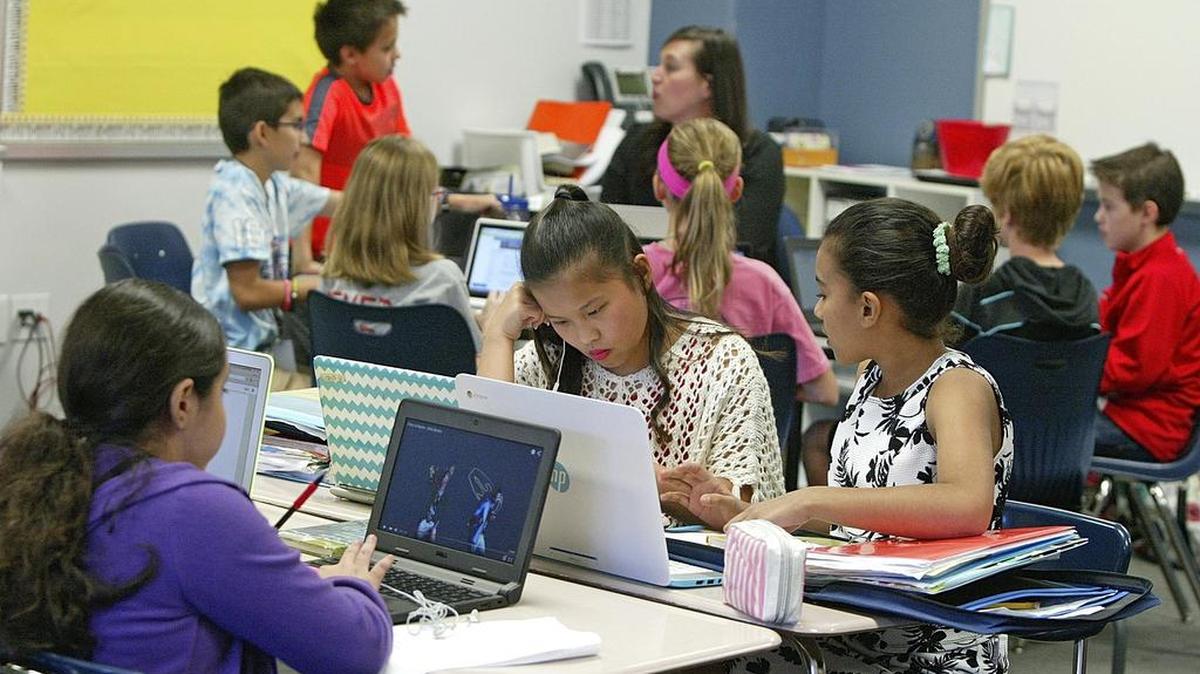 Students in a dual language class at Grapevine Middle school study while teacher Haley Wise works in the back of the classroom with a small group.