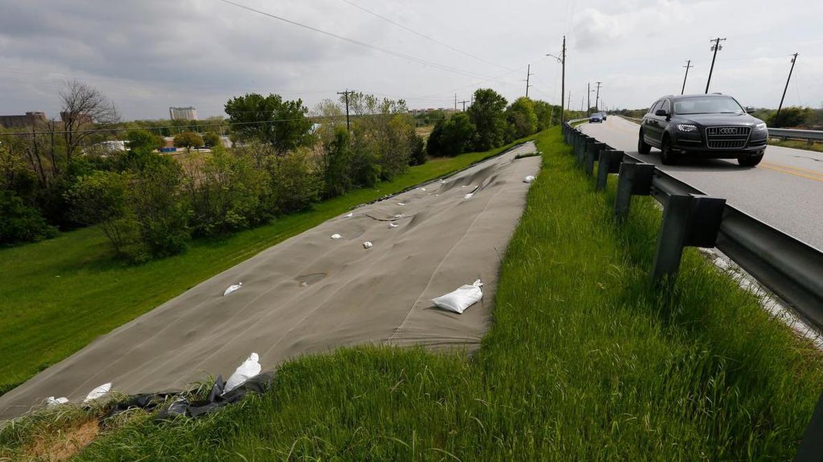 A large tarp covers an eroded area on the dry side of the Lake Grapevine dam March 29. Fairway Drive re-opened Saturday.