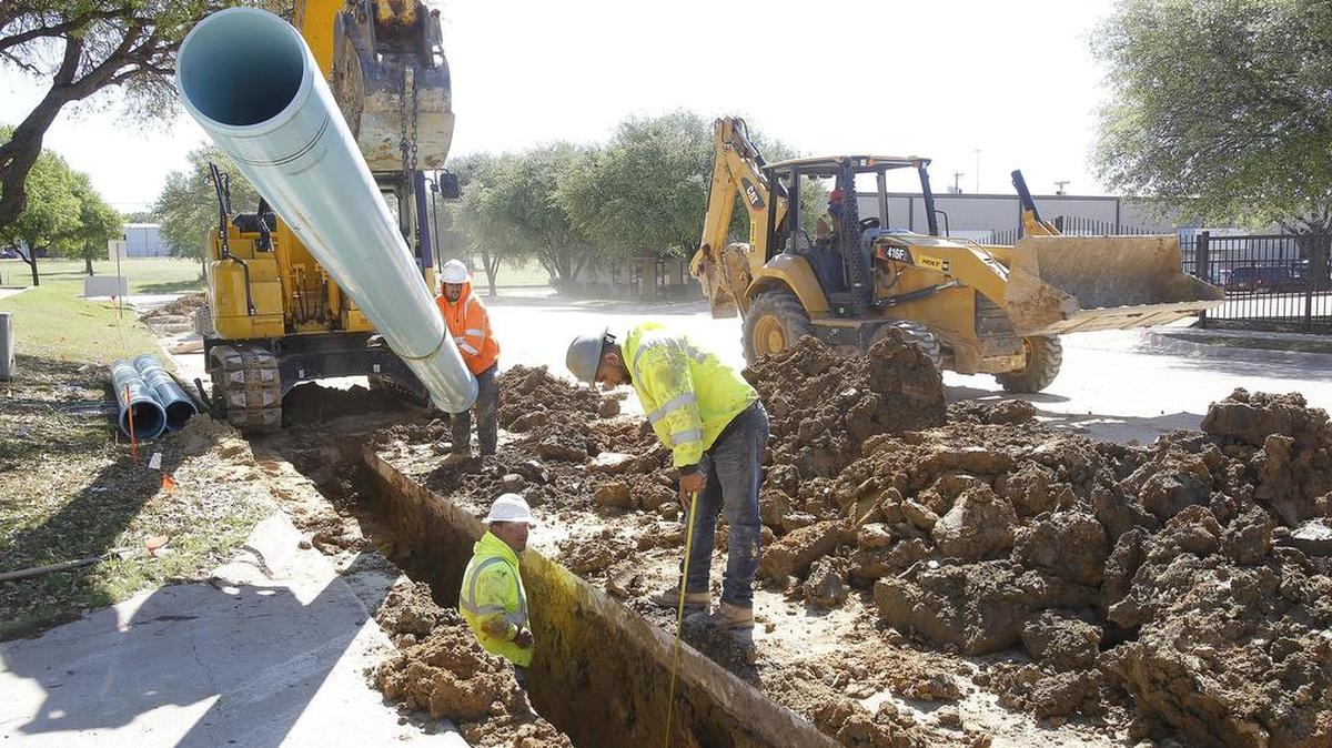 Construction crew works on a water main in Bedford on March 30.