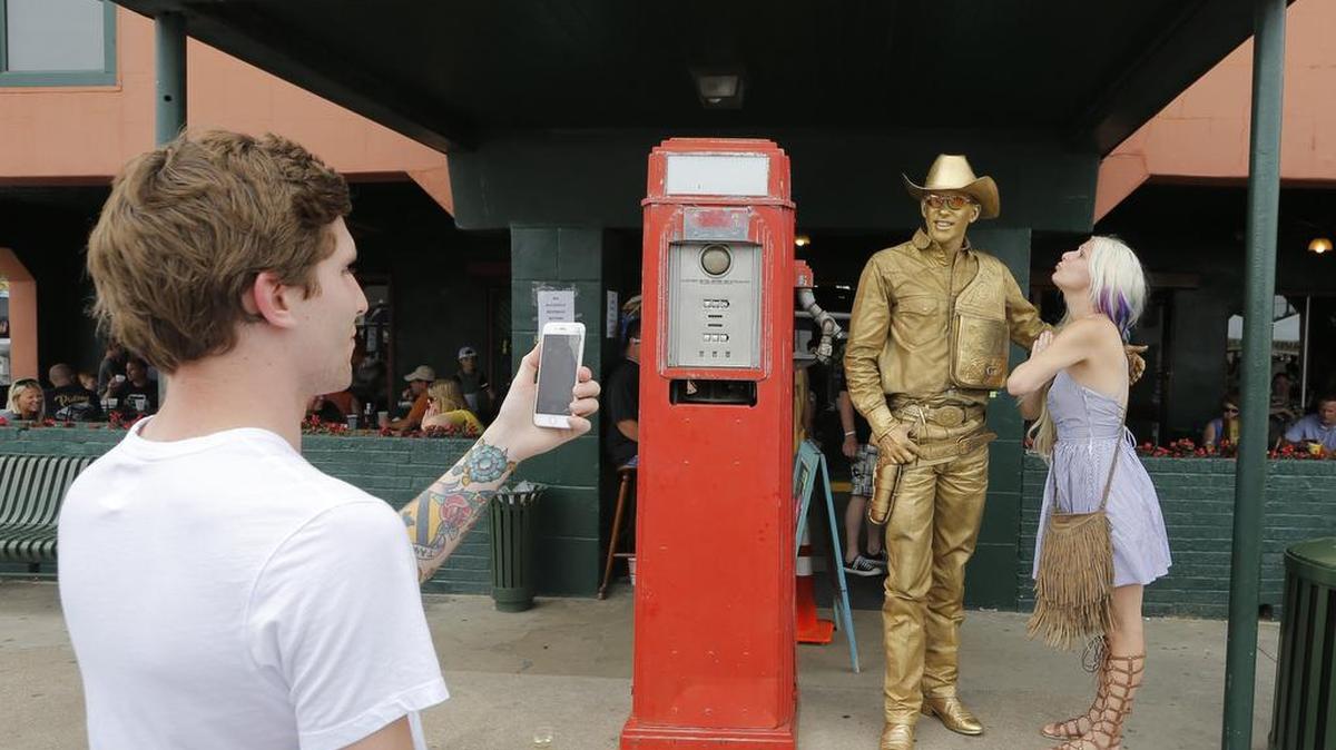 Lucas Whitaker takes a picture of his aunt Katielynn Whitaker with The Golden Cowboy at Grapevine’s 32nd Annual Main Street Fest A Craft Brew Experience.
