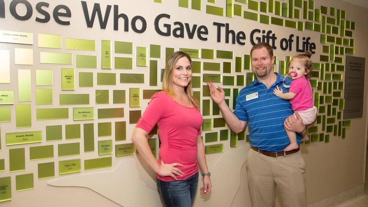 Jaron and Tiffany Peek with their daughter Kaili at the Living Donor Wall at Baylor Scott & White All Saints Medical Center in Fort Worth.