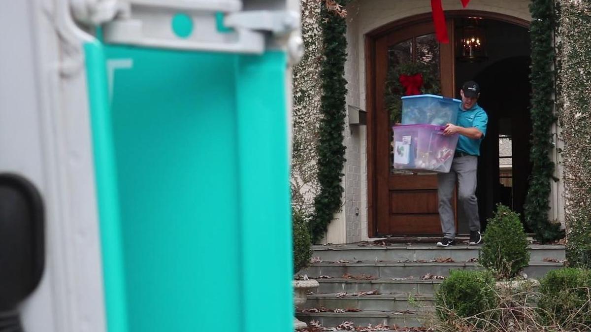 Luke Collins of Callbox Storage picks up some items at a home and walks them to the van to be transported to their facility in Grapevine.