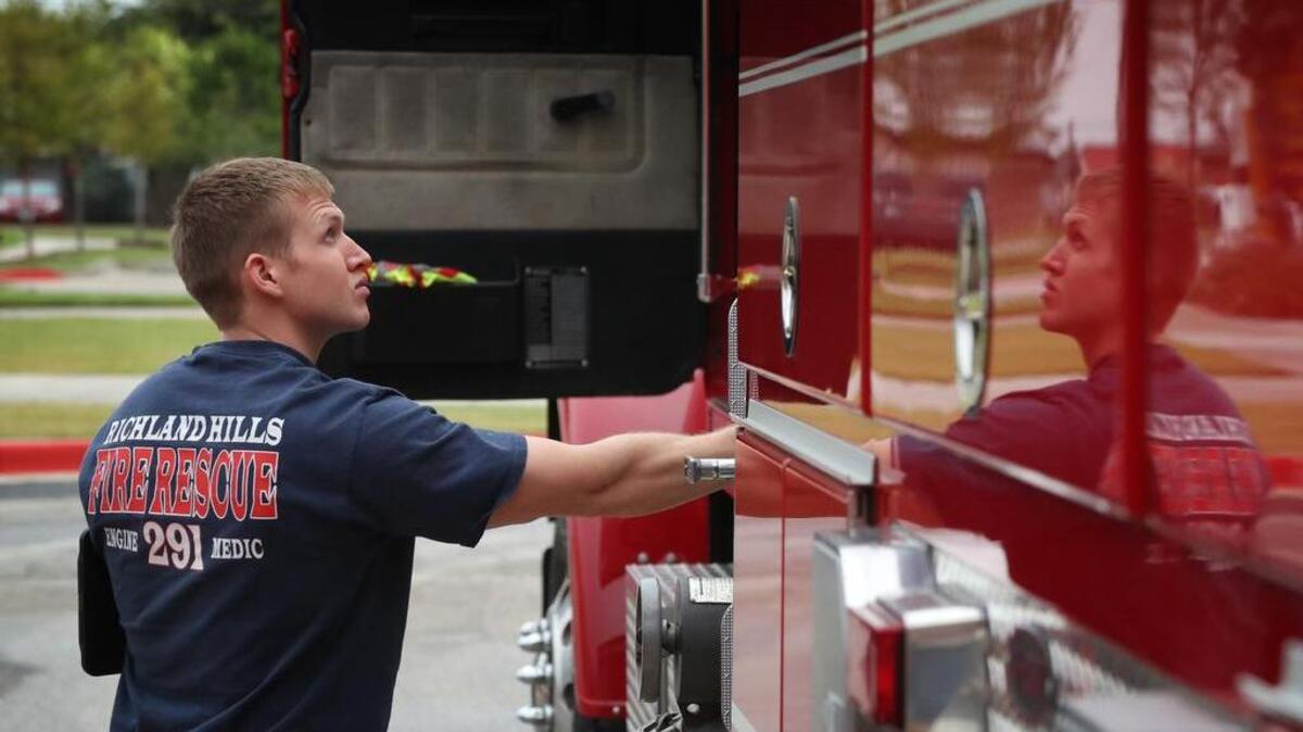 Firefighter paramedic Christopher Carter checks out the reserve fire engine as firefighters get ready for their shift at the Richland Hills Fire Rescue station.