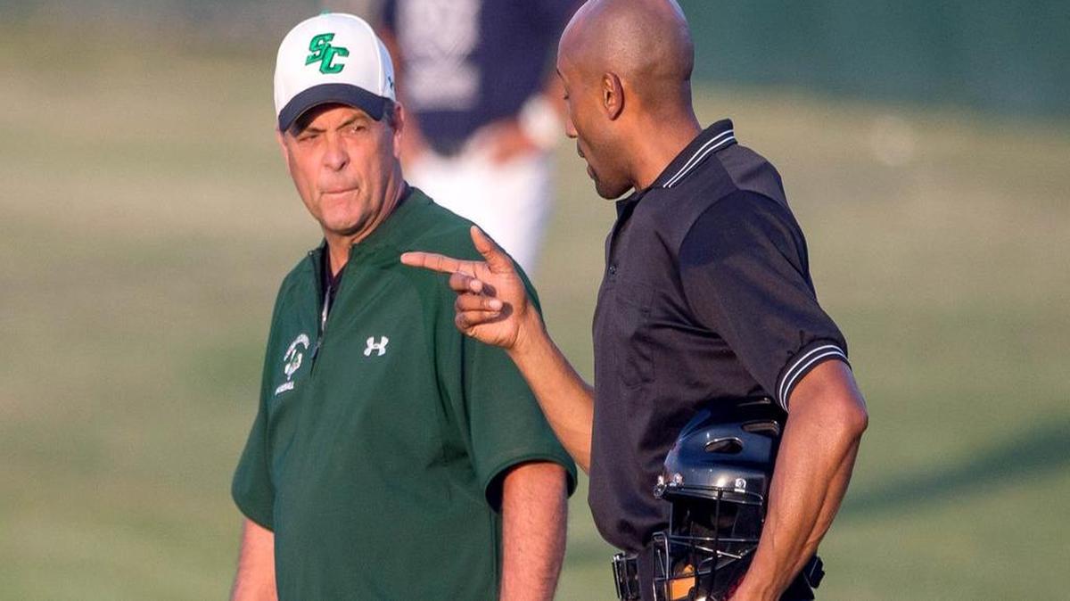 Southlake Carroll head coach Larry Hughes talks with an umpire in a 2014 playoff game. Hughes announced his retirement last week.