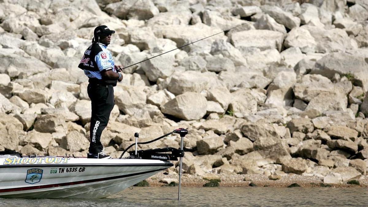 A fisherman near the rocky slope of Lake Grapevine’s dam.