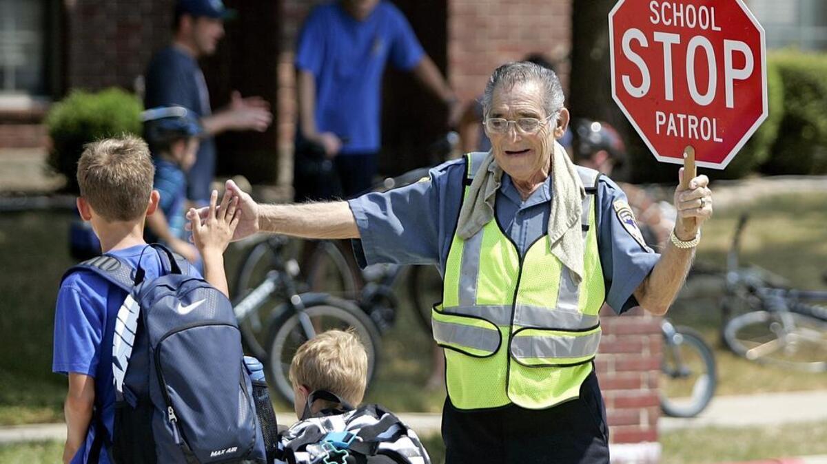 
Alvin Peters, 74, greets students as they cross the street in front of Beck Elementary School in Trophy Club last week.
