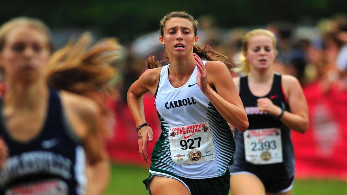 Carroll’s Ali White, center, competes in a 2016 cross country meet.