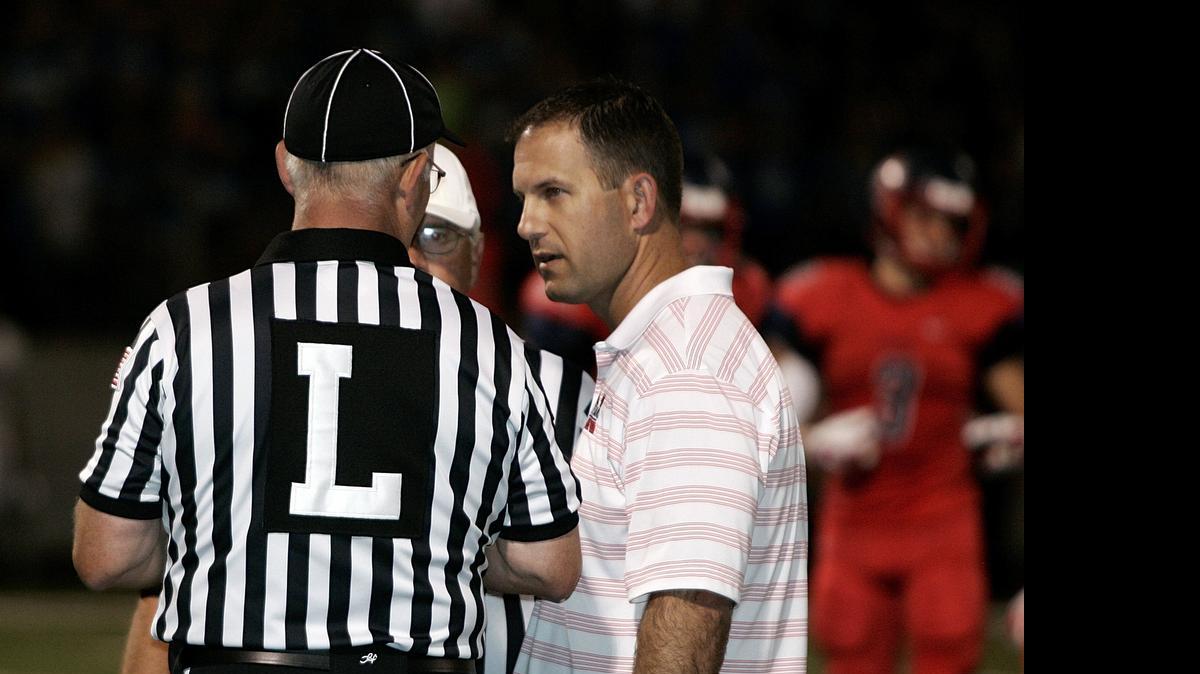 
Northwest head coach Bill Poe talks with the linesman last season. Poe, who suffers from 75 percent hearing loss, relies on a hearing aid and lip-reading.
