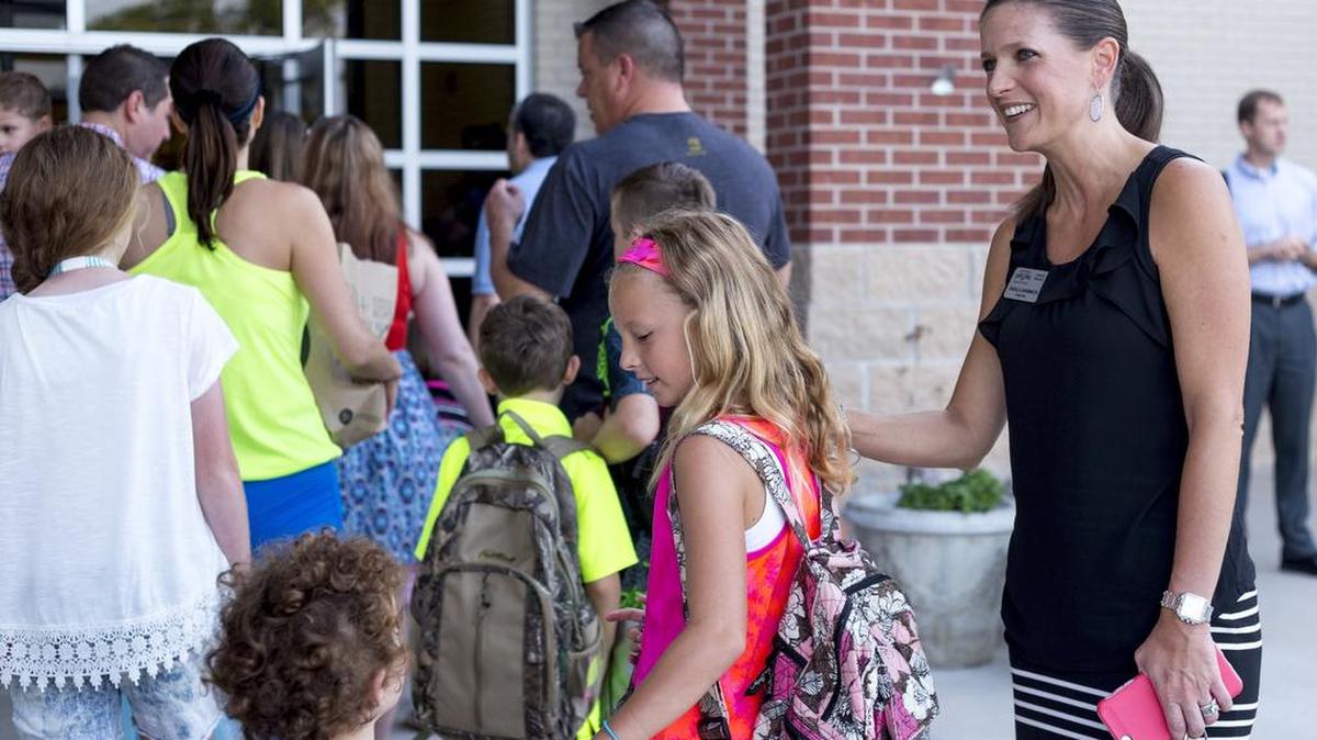 Colleyville Elementary principal Sheila Shimmick greets the incoming students and their parents on the first day of the 2015-16 school year.