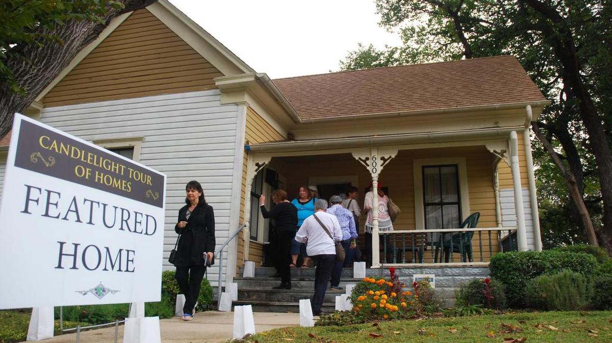 Visitors enter and leave the home of Tom and Jeanette Frick on West College Street during the Grapevine Candlelight Tour of Homes. The home, built in 1902, was originally owned by the W.R. Buckner family.
