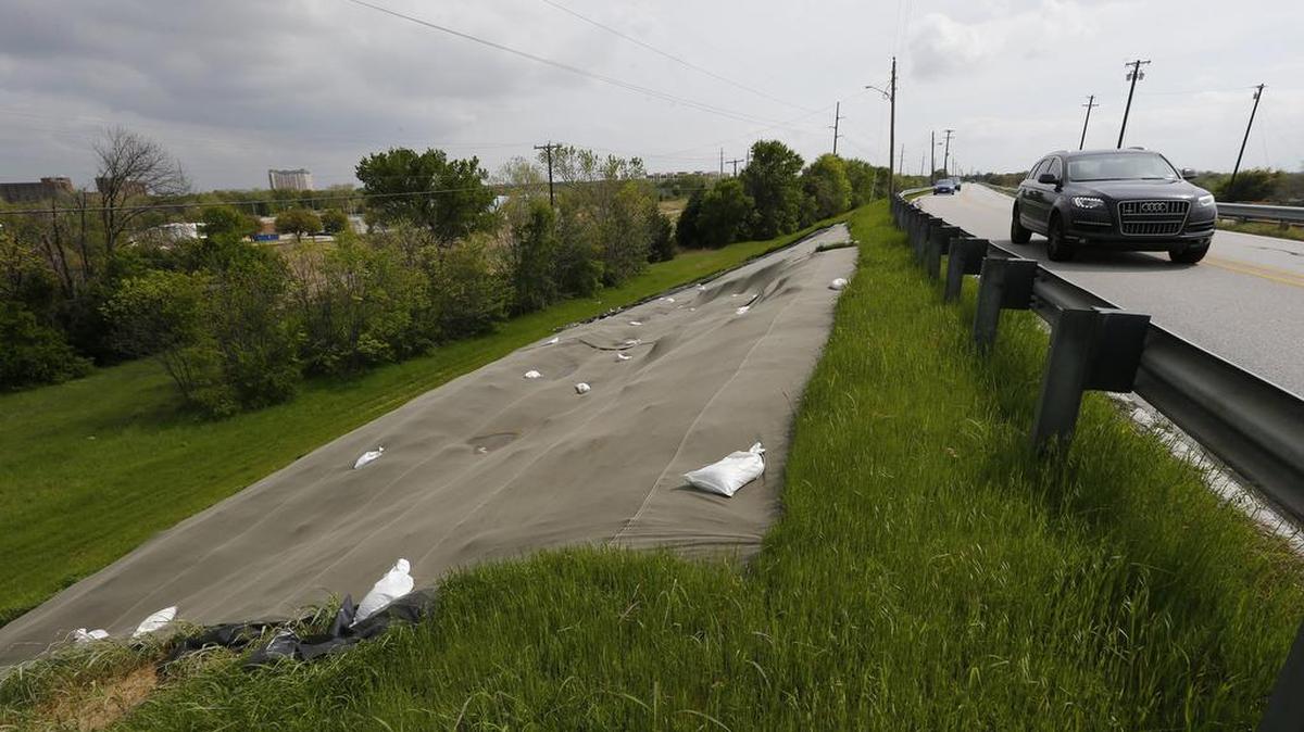 A large tarp covers an eroded area on the dry side of the Lake Grapevine dam. Repairing the dam will cause Fairway Drive to be closed.