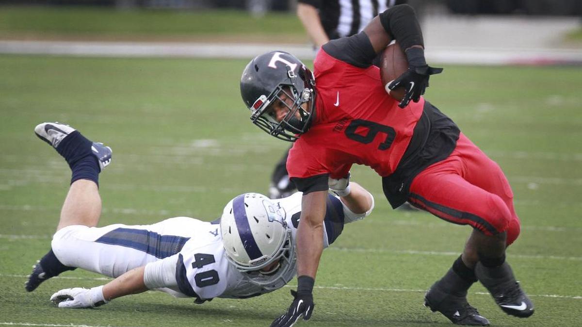 Tom Herrera (40) of Richland brings down Trinity’s De'Jaun Garrett (9) last Friday.