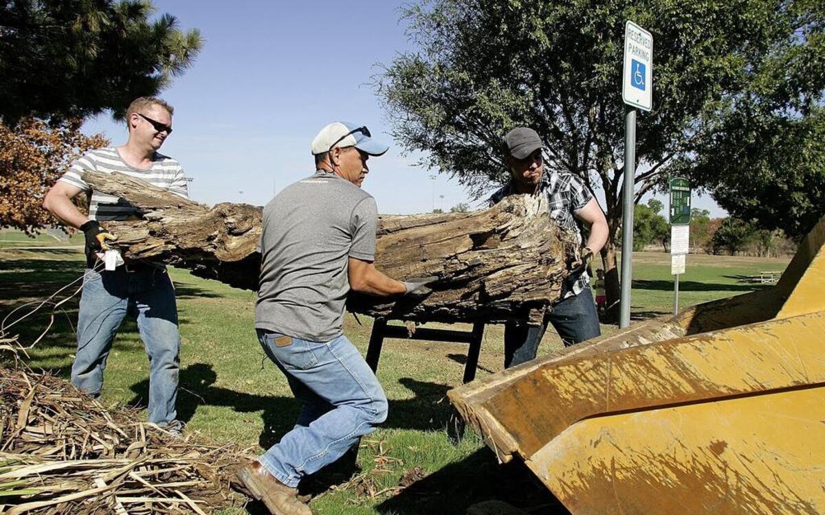 
Tim Ryder, Tony Le and Alex Stroud load a tree trunk into a front end loader during Project Restore Flood 2015 at Lake Grapevine.
