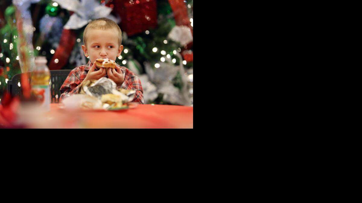 
Andrew Addison, 4, eats his breakfast while waiting for Santa Claus. 
