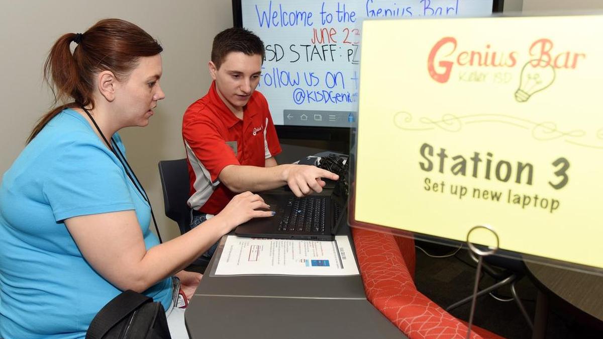 Tenth-grade teacher Teresa Nguyen, left, gets some help setting up her laptop computer from student Christian Shaw at the Keller ISD's Genius Bar.