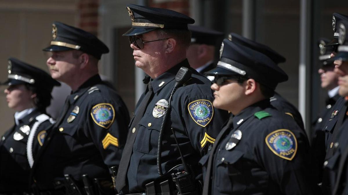 A parade of Colleyville police officers stand at attention during the Peace Officer Memorial held at the Colleyville Justice Center in Colleyville. The department honored officer Dennis Edward Harrell, who died in the line of duty in 1980.