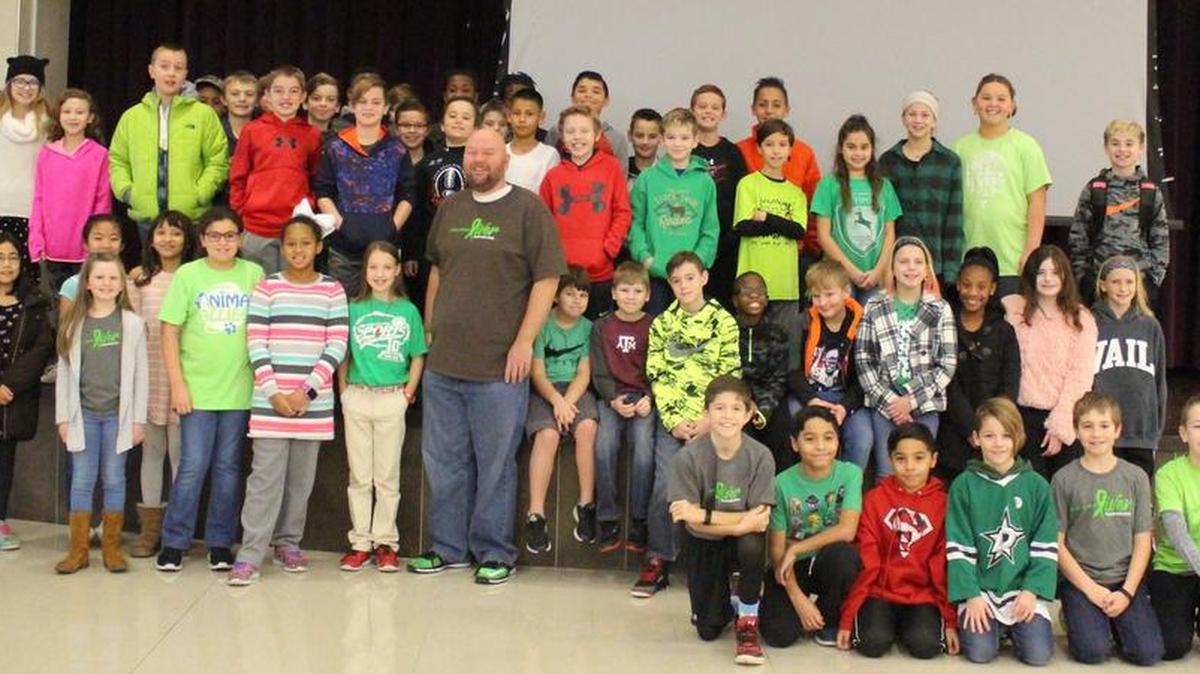 Teacher Michael Shaw poses with his fifth-grade students Jan. 4 at Timberview Middle School. The school was celebrating “Go Green for Mr. Shaw Day” to raise money to help with Shaw’s medical expenses related to liver cancer.