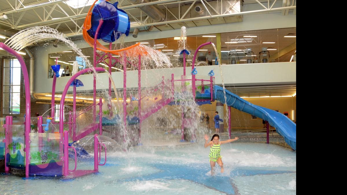 
Hannah Kelley is suprised by the water that falls on her as she wades in the pool of the new aquatic center during the opening of The REC of Grapevine, 
