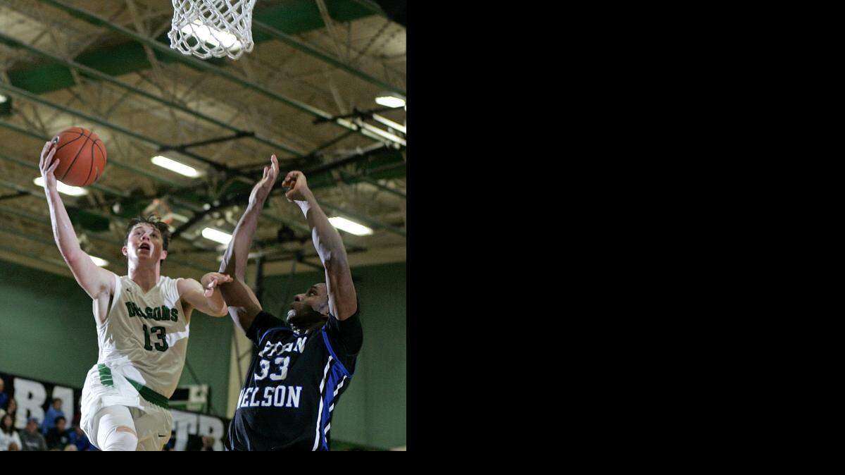 
Carroll guard Kirk Mason (13) shoots over Byron Nelson forward Emmanuel Nzekwesi (33) in last week’s Dragons victory.
