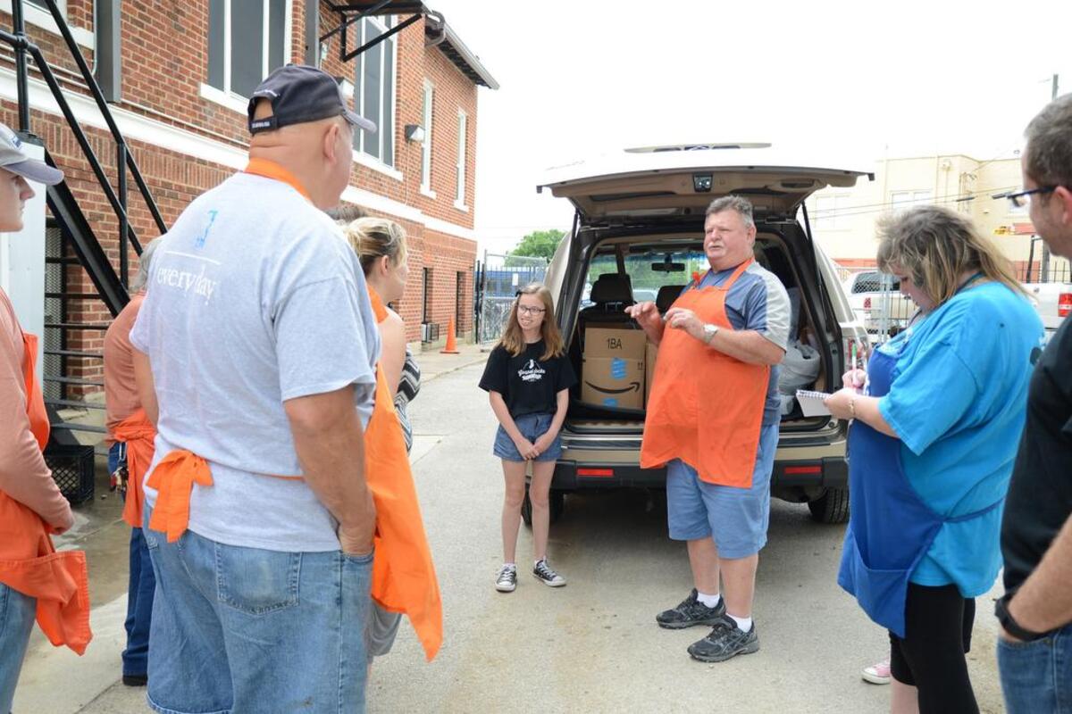 Beutiful Feet volunteer Tom Grier, 61, of Benbrook, tells other volunteers how Emily West, 12, of Fort Worth has donated nearly 1,500 socks.
