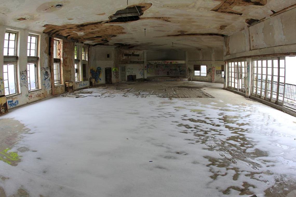 In a 2014 file photo, the floor of the rooftop ballroom is covered in snow. Most of the doors and windows on both sides are missing.