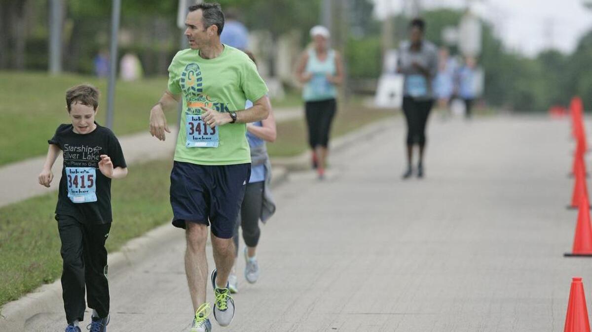 Jack, 9, and John Tieken lead a pack of runners on the last leg of Rachel's Run at Colleyville High School April 16, 2016.