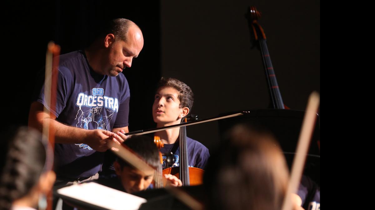 
Orchestra director Travis Sampson does an instrument check with Mark Poveda.


