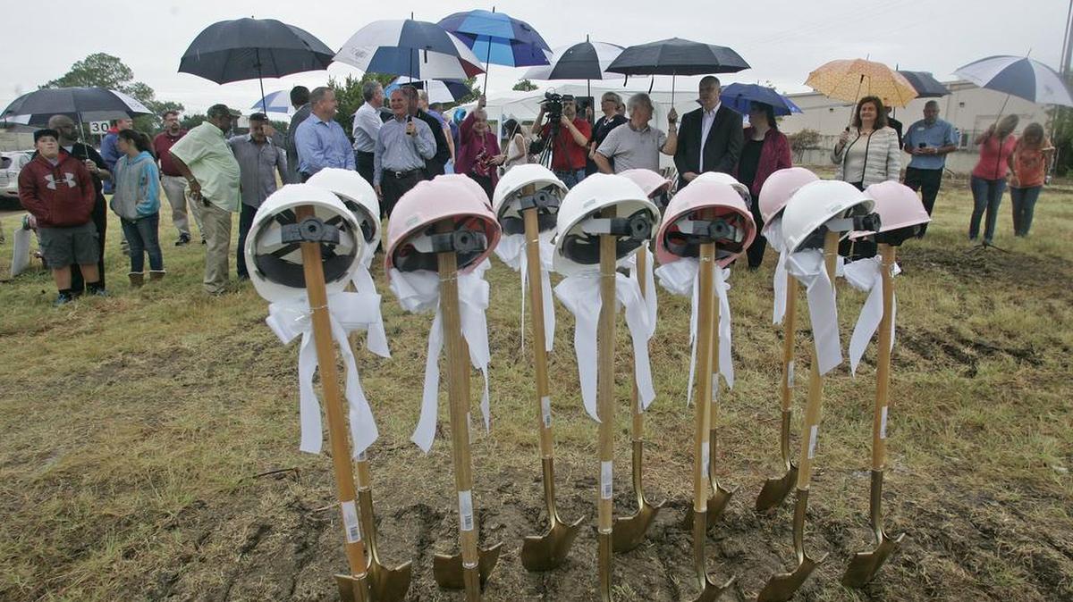 Residents, city officials and development representatives wait in the rain Aug. 15 for the groundbreaking ceremony for Euless Founders Park. The project was made possible after razing three rundown apartment buildings.