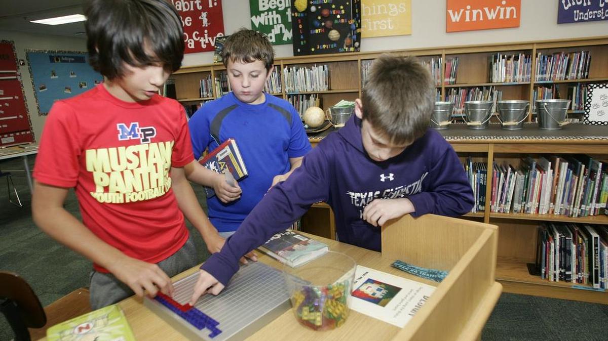 Victor De La Cruz, 11, Damion Cohen, 11, and Peyton Baxter, 10, assemble a puzzle using Synergy.