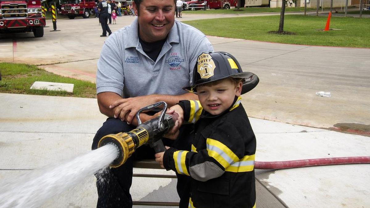 Colleyville Fire Department Engineer/Paramedic James Biggs helps Braden Wroble of Keller operate a red line hose.