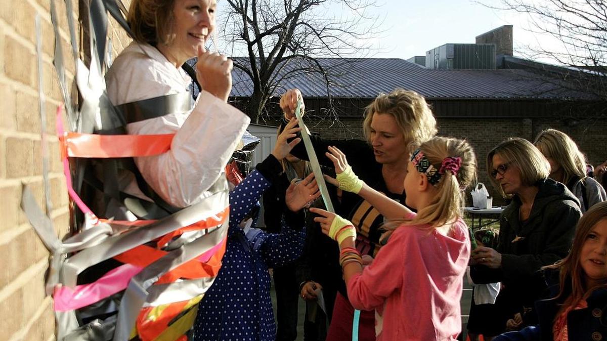 Principal Stacy Wagnon is duct taped to the wall by students and staff during the PTO Spring Fundraiser at Carroll Elementary Friday.