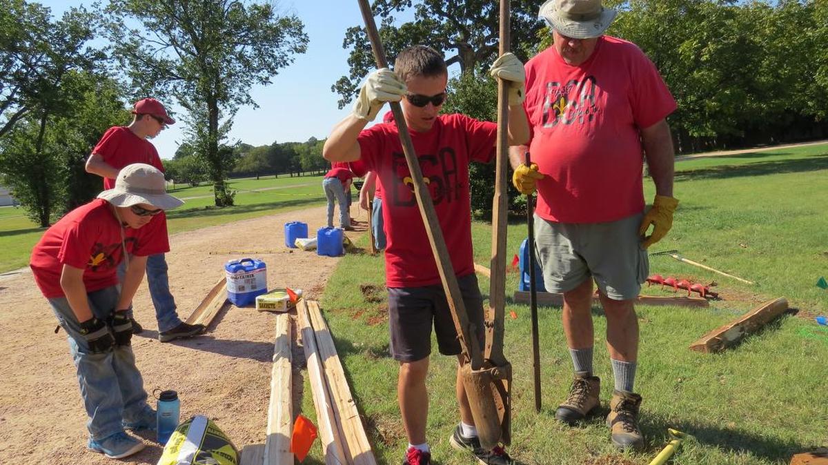 Joshua Smalling, center, lifts dirt with a posthole digger as Ryan Hooper, left, and Richard Sea assist during an Eagle Scout project Oct. 2 at Old Bedford School.