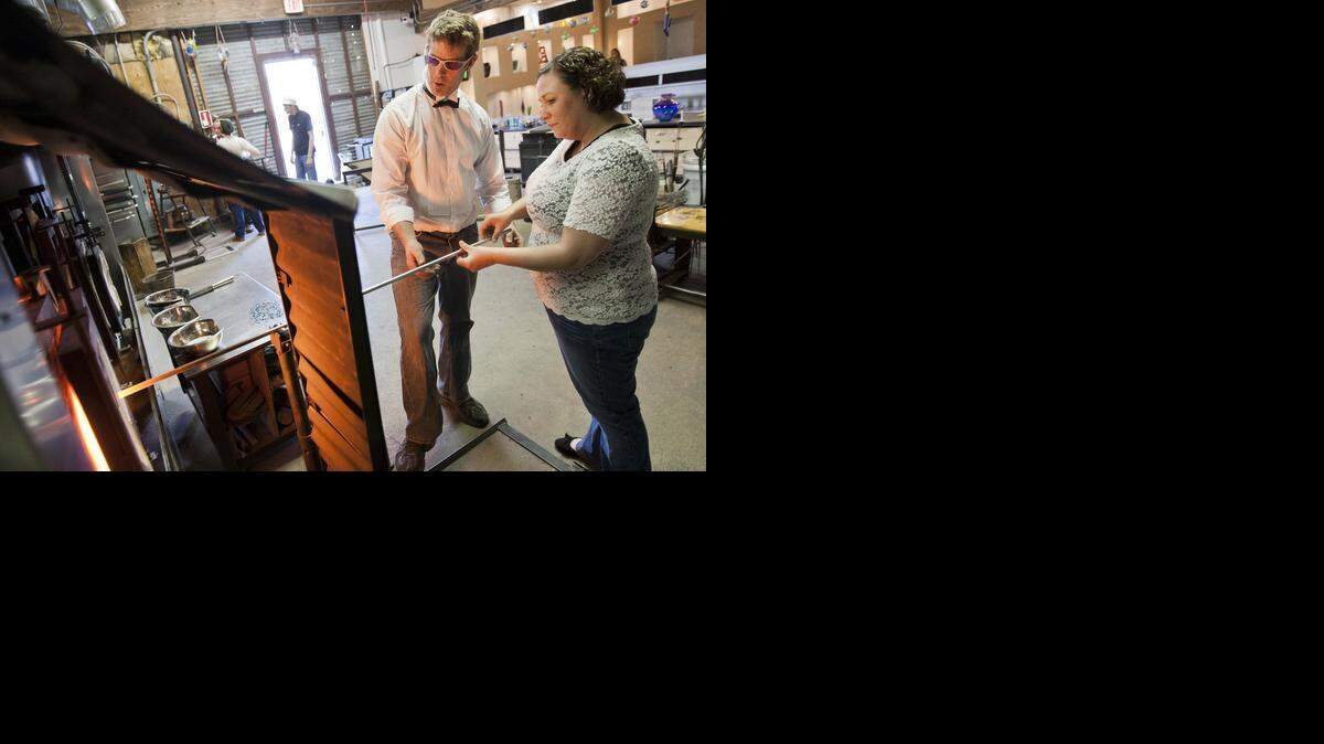 
Glass artist Spencer Crouch helps Ashley Redford make a glass rose at Vetro. 
