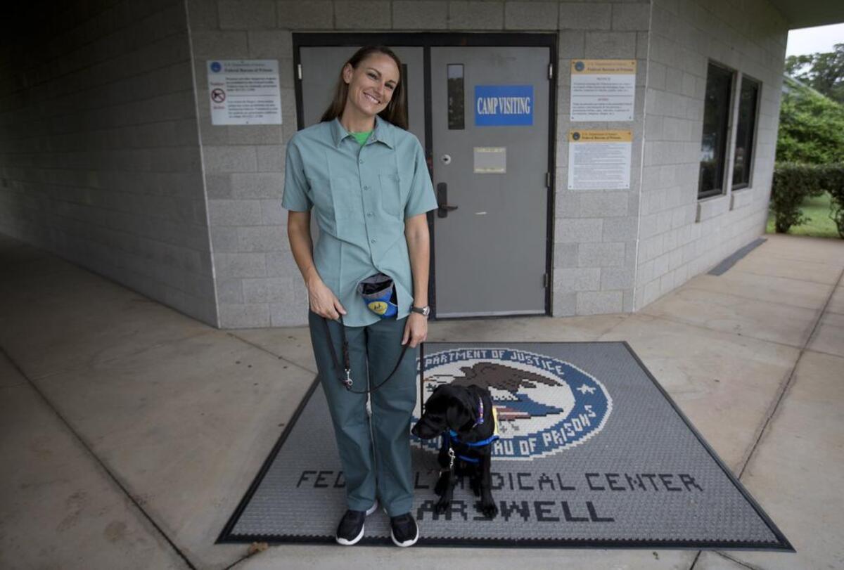 Female inmate Kristen Simonson with her puppy-in-training Gully at Fort Worth’s federal prison for women.