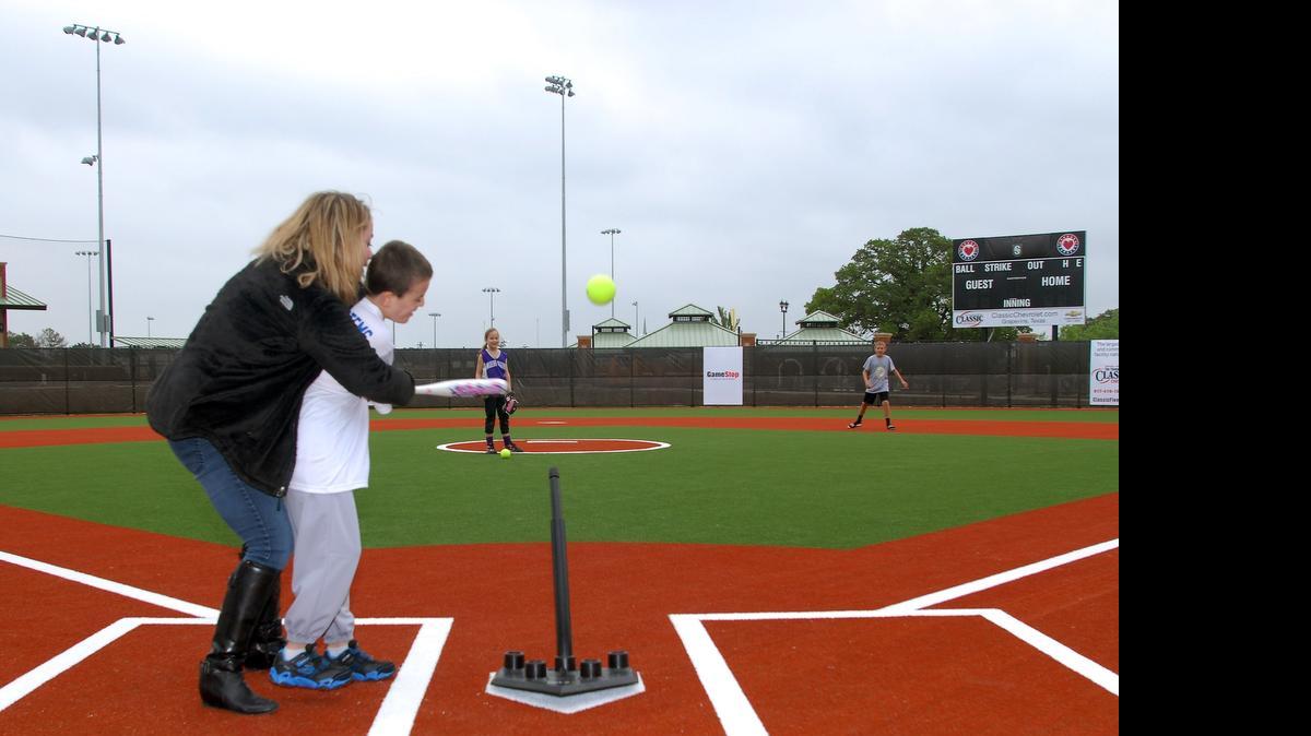 
From left: Andi Stone, executive director of Miracle League Southlake helps her son Carson hit the ball. 
