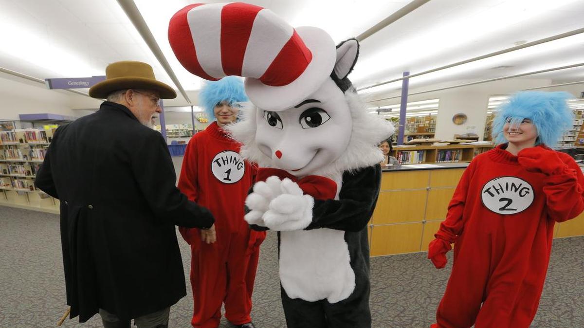 Mayor William D. Tate, dressed as Sam Houston, meets Kenneth Wilkinson (Thing 1), Eric Monreal (Cat in the Hat) and Robyn Robisheaux (Thing 2) as the Grapevine Public Library opens new areas in a 1,500-square-foot expansion.
