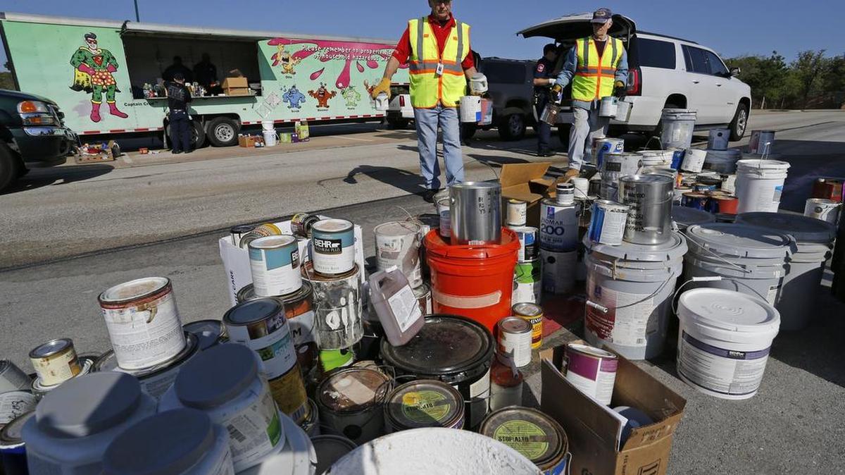 Volunteer Ken Stewart (center) carries paint from a vehicle dropping off. The Southlake Fire Department had the Crud Cruiser March 26 at Dragon Stadium for residents to bring their household hazardous waste, as well as electronics and documents for recycling and shredding.