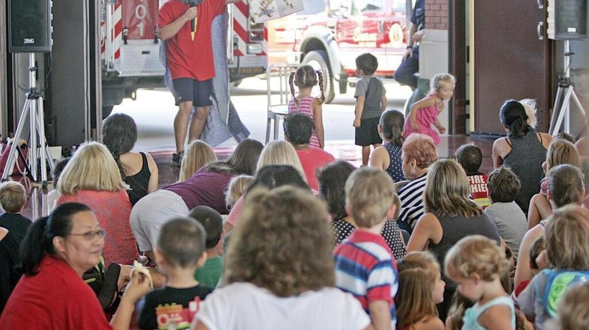 
Southlake FIre Department Engineer Ricky Davis reads Super Hair-O and the Barber of Doom at Southlake Fire Station 1July 24. 
