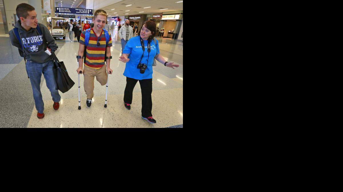 Yuri Day of <137>(left,<137> Houston, left, Josiah Puyera of Boerne <137>(right, Boerne) <137>and American Airlines worker <137>staff member <137>Sam Seelbach make their way to the departure gate.<137> Teens from across the state, all amputee or limb-loss patients at Texas Scottish Rite Hospital, left from DFW Airport aboard a American Airlines plane for their annual ski trip to Colorado, Monday, February 9, 2015. <137>