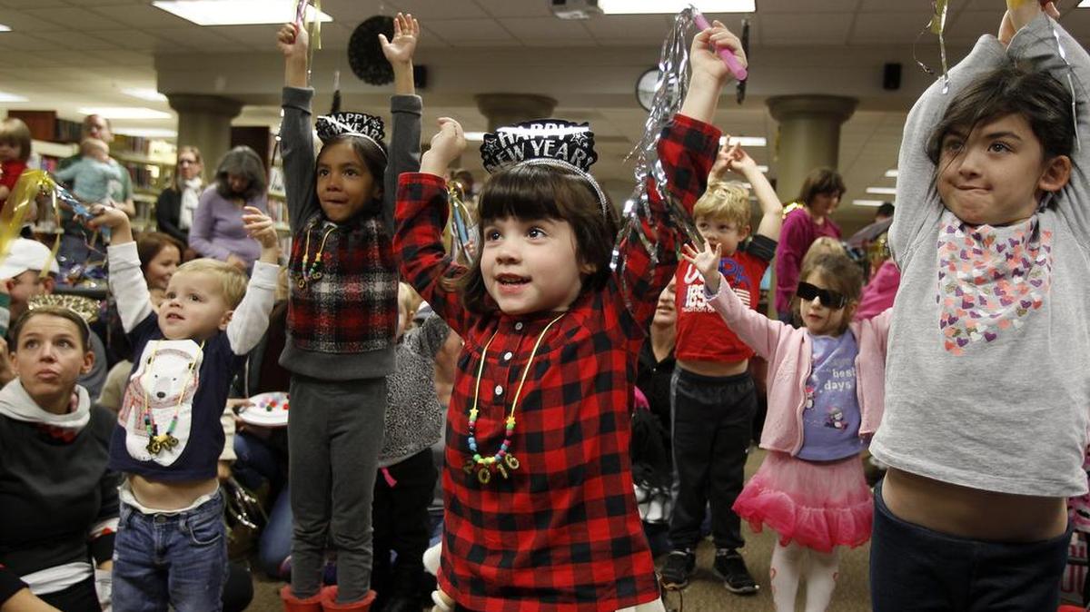 Madeline Gillispie, 4, visiting from Willis, center, plays a game at the Southlake Public Library.