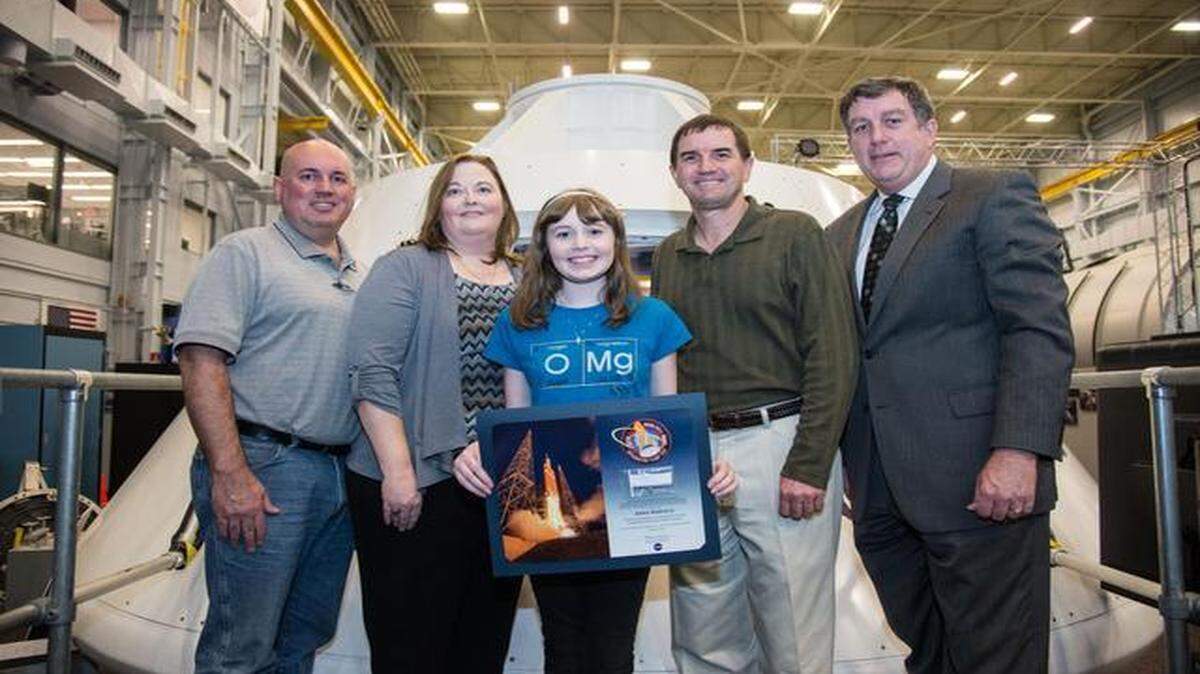 
Anna Marceca receives a plaque from a NASA official at Johnson Space Center in February. Anna gave a fossil to NASA to fly on Orion’s first test flight in December.
