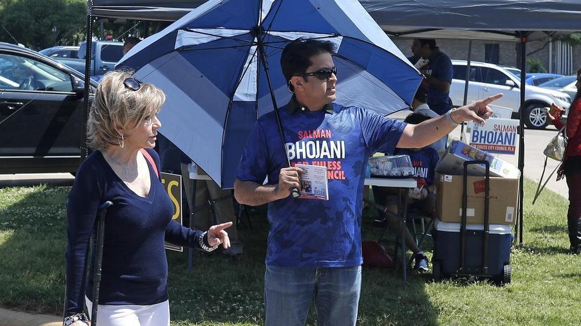 Debby Jackson talks with Salman Bhojani volunteer Ifti Khan during voting Saturday at the Euless Public Library.