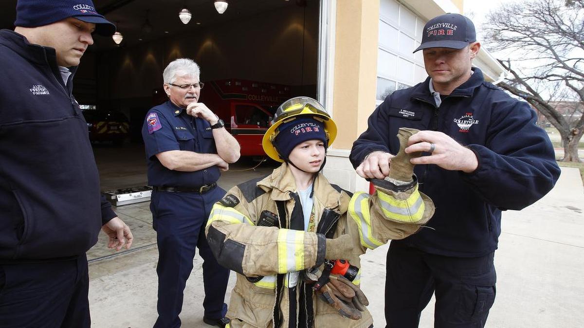 Firefighter/EMT Thomas Williams, right, gives 11-year-old Coleman Elam a tour of the Central Fire Station after he won a contest to be mayor for the day at Colleyville on January 5, 2016.